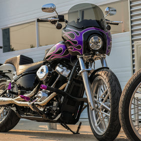 Custom black cruiser motorcycle with purple flame fairing and smoked windshield