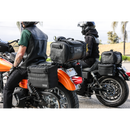 Thrashin Supply Co. Expedition Saddlebags in black ballistic nylon with MOLLE attachments and metal g-hook lids for Harley-Davidson Softail, Dyna, and FXR models