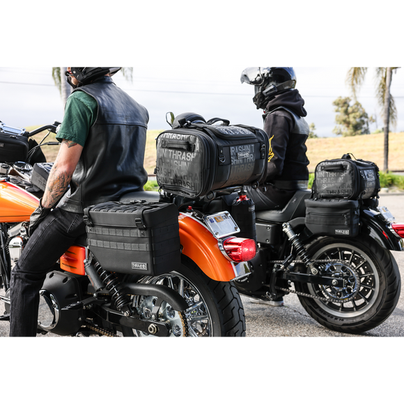 Thrashin Supply Co. Expedition Saddlebags in black ballistic nylon with MOLLE attachments and metal g-hook lids for Harley-Davidson Softail, Dyna, and FXR models