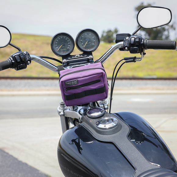Thrashin Supply Co. ballistic nylon handlebar bag with YKK zippers and quick-attach straps mounted on Harley-Davidson handlebars