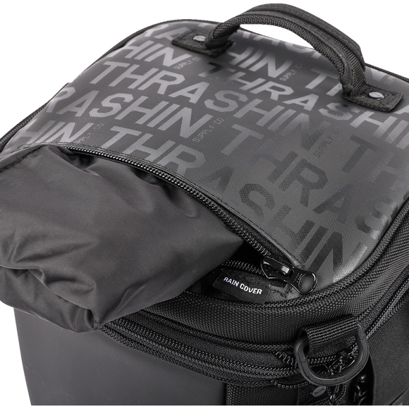 Thrashin Supply Co. Passenger Bag in black ballistic nylon with expandable dual-zipper design and hi-viz orange interior