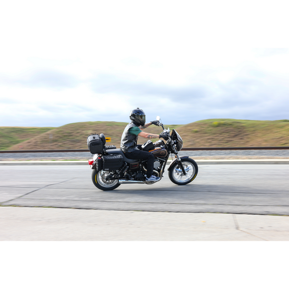 Thrashin Supply Co. Passenger Bag in black ballistic nylon with expandable dual-zipper design and hi-viz orange interior