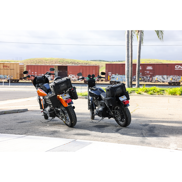 Thrashin Supply Co. Passenger Bag in black ballistic nylon with expandable dual-zipper design and hi-viz orange interior