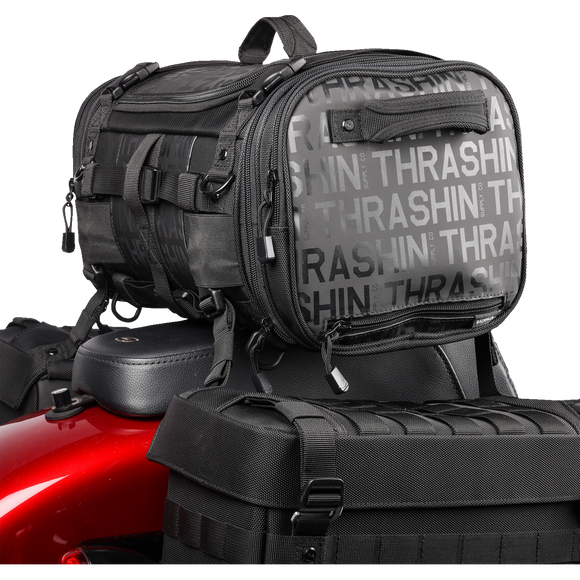 Thrashin Supply Co. Passenger Bag in black ballistic nylon with expandable dual-zipper design and hi-viz orange interior