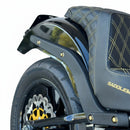 Close-up of Bamco ARP stainless steel bolts (gold) securing rear fender and strut on 2018+ Harley‑Davidson Softail, black quilted seat and rear wheel visible