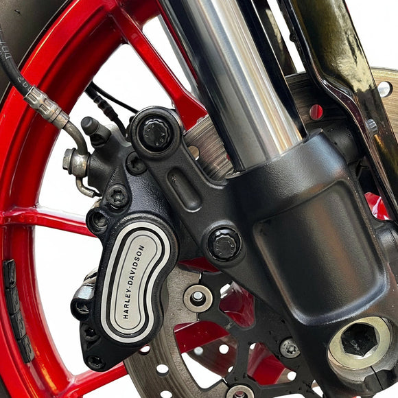 Bamco ARP stainless steel front caliper bolts installed on Harley‑Davidson black brake caliper with red wheel