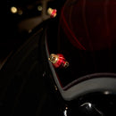 Close-up of Bamco red anodized cap covering ARP stainless steel bolt on black Harley-Davidson motorcycle near taillight