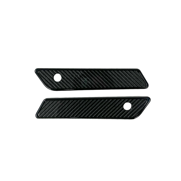 Pair of black slim-line saddle bag latch covers with carbon fiber inserts for 2014–2023 Harley‑Davidson Touring models (Part 104725B)