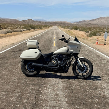 Lowrider ST Motorcycle with a solo tour pack mount for 2 up seats on a desert road with a clear sky.