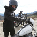 Cole Seely in black Thrashin Cold weather Gauntlet Gloves and motorcycle gear with a white Harley-Davidson motorcycle in a mountainous area.