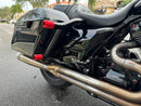 Red saddlebag guard sliders on black bagger motorcycle with dual stainless exhaust