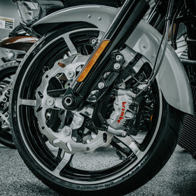 Close-up of OG Moto 320mm Complete Radial Brake Kit installed on a 2024-Up Harley-Davidson Touring motorcycle, showing the solid mount wave rotor, Brembo radial caliper, and CNC-machined radial bracket on the front wheel.