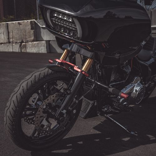 Black bagger motorcycle front with red fork clamps and LED headlight