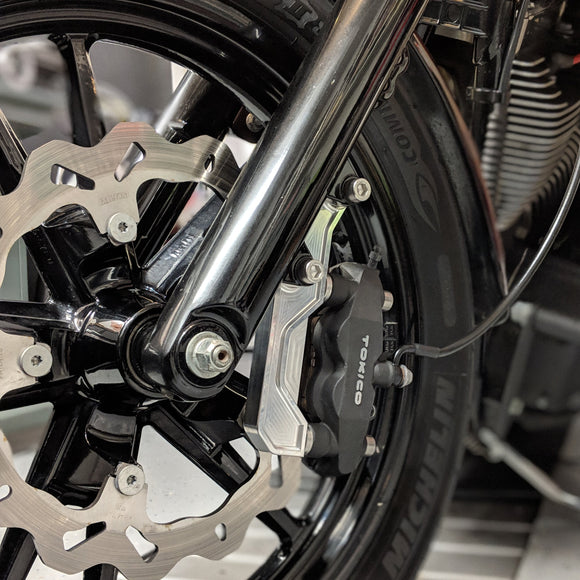 Original Garage Moto OG radial-mount brake caliper bracket mounted on motorcycle front wheel