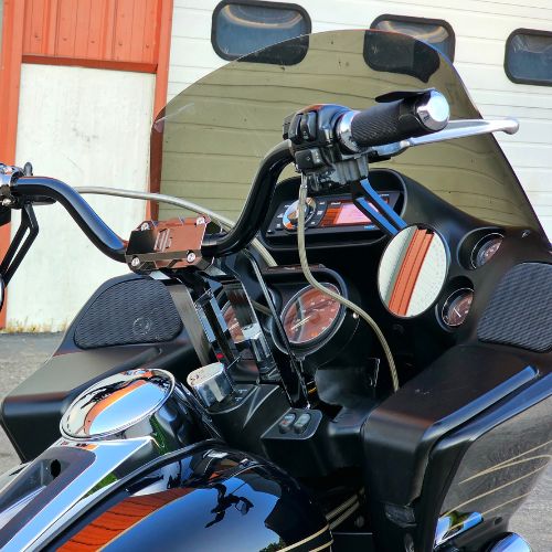 Motorcycle handlebar risers on black touring bike with windshield and gauges