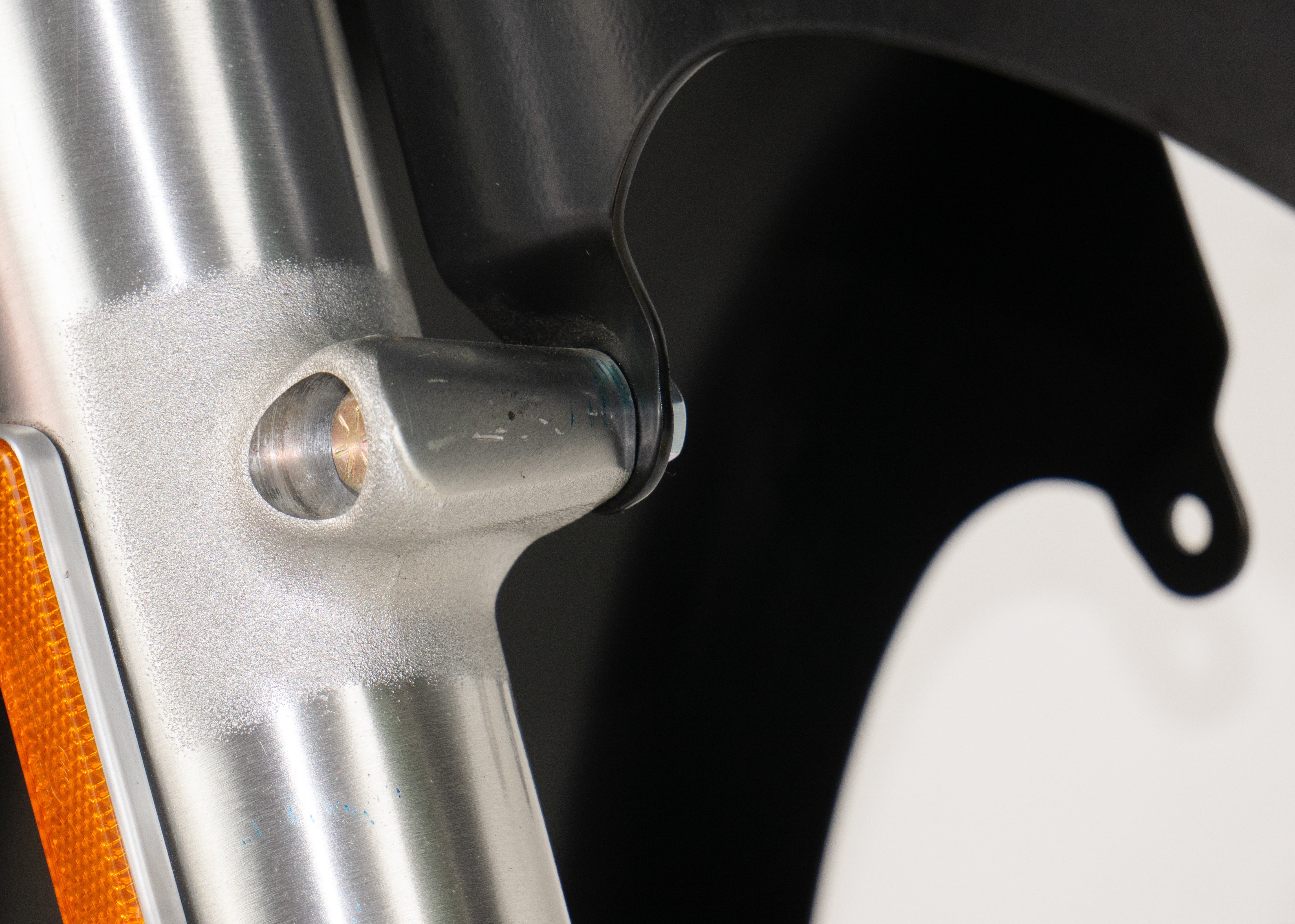 RWD V-Twin 8-inch wide LS-2 black motorcycle front fender close-up showing fork mount bolt and amber reflector