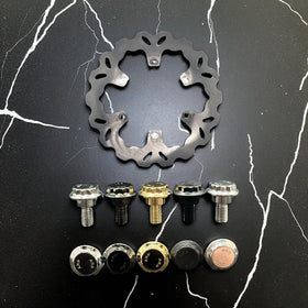 Bamco ARP stainless steel Harley‑Davidson rotor bolts (set of 5) in chrome, black chrome, gold and black finishes displayed beneath a fixed wave rotor